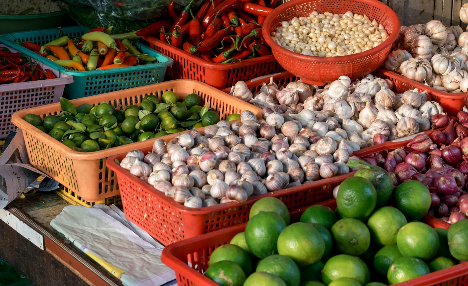 Baskets of limes, garlic, chillies and onions at a fresh produce market in Saigon