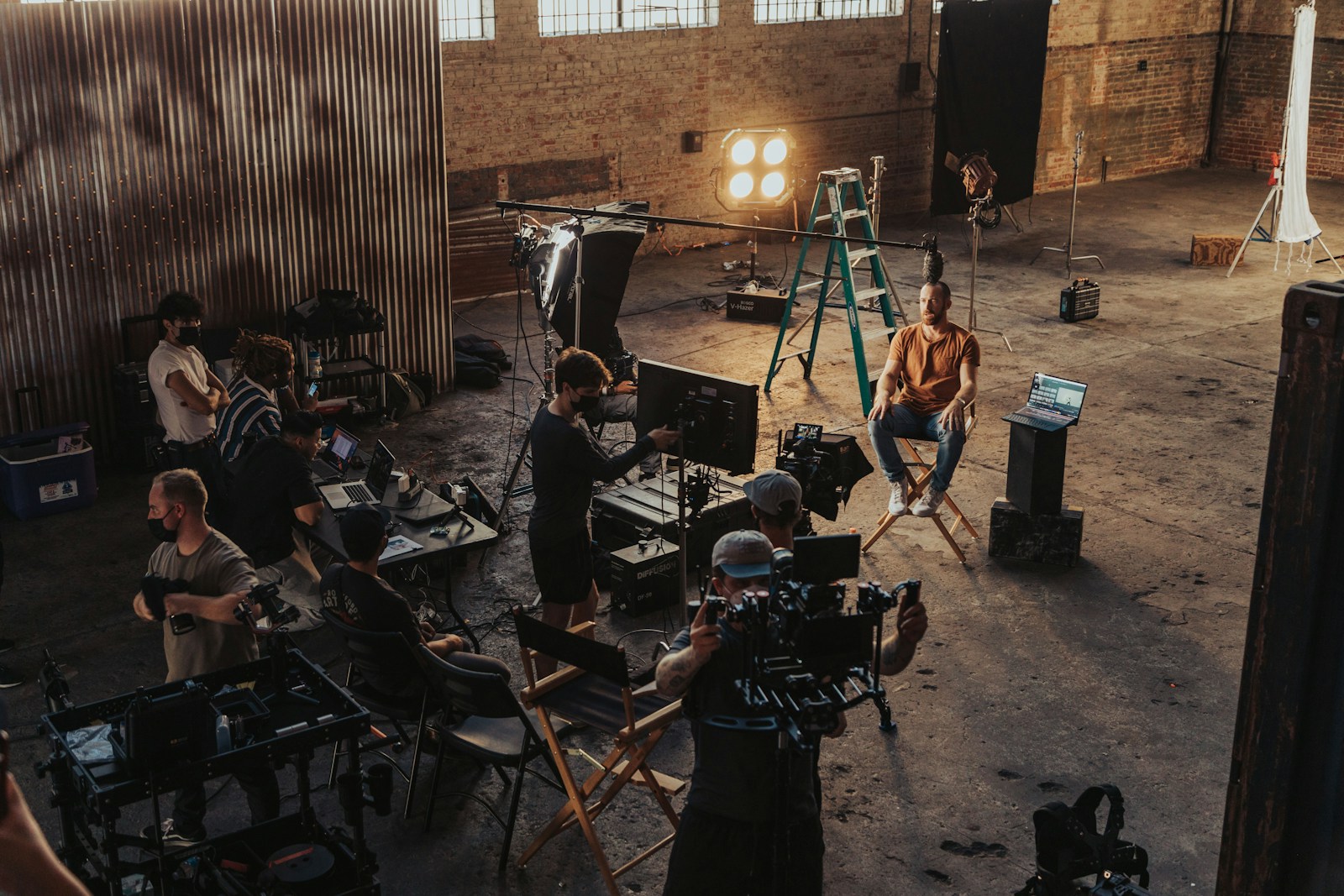 A film crew gathered around camera and lighting equipment on a production set