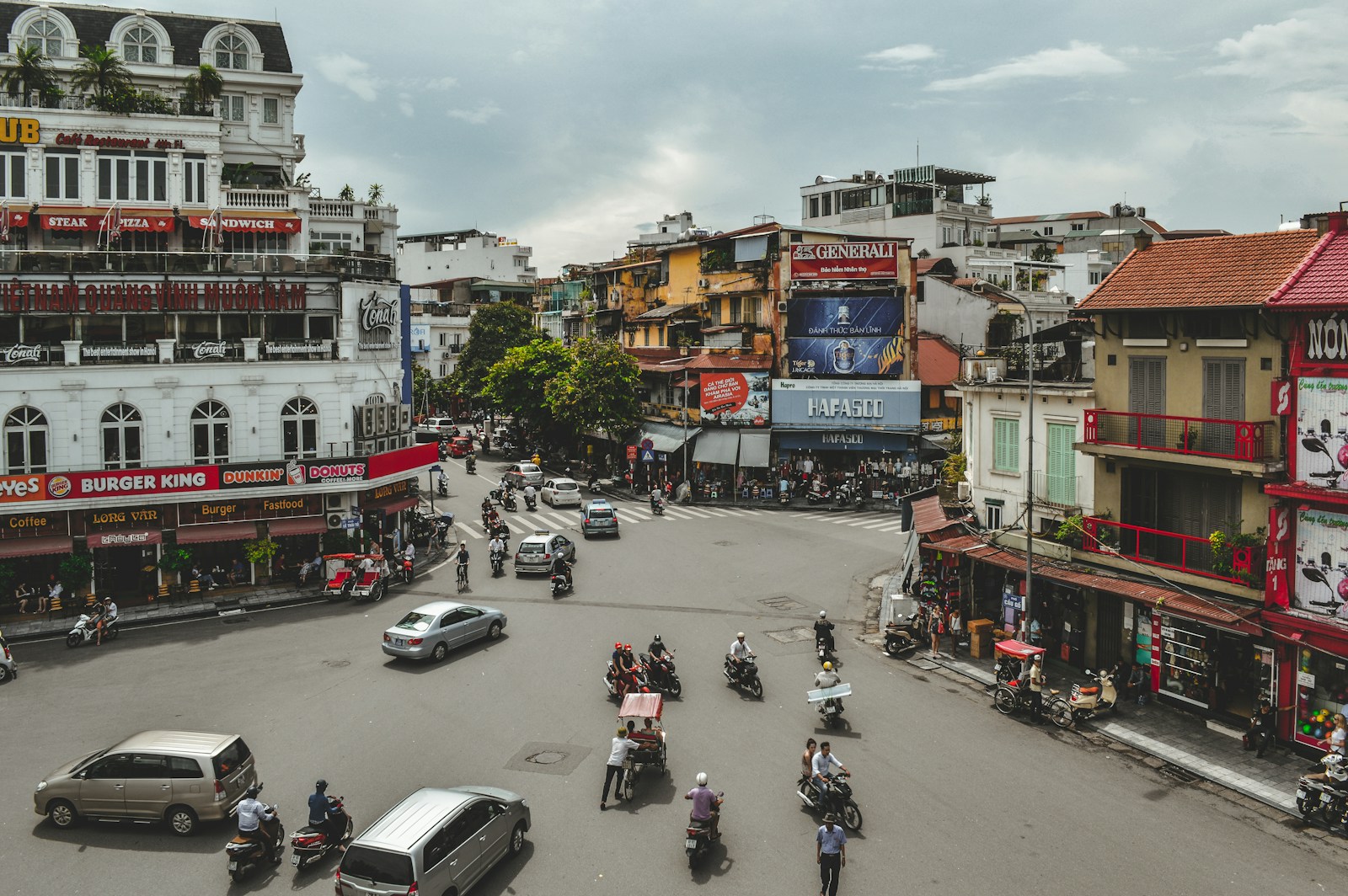 Street scene in Vietnam with traffic and shopfronts at dusk