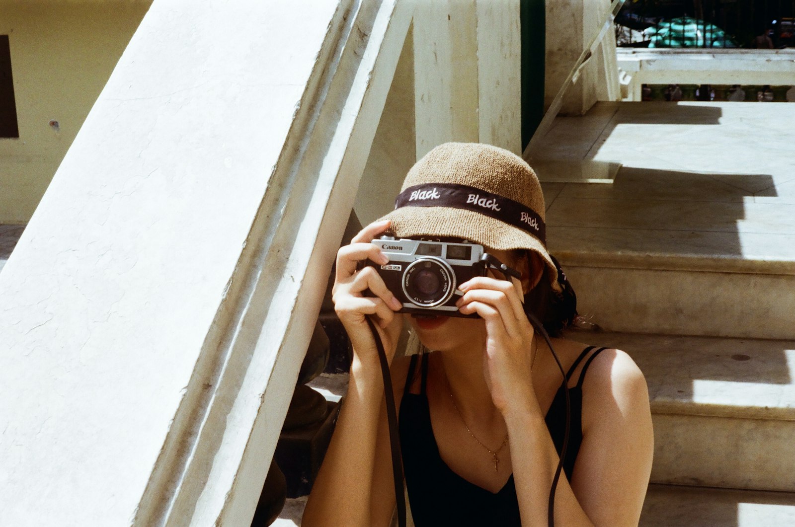 A woman holding a DSLR camera on a street in Ho Chi Minh City