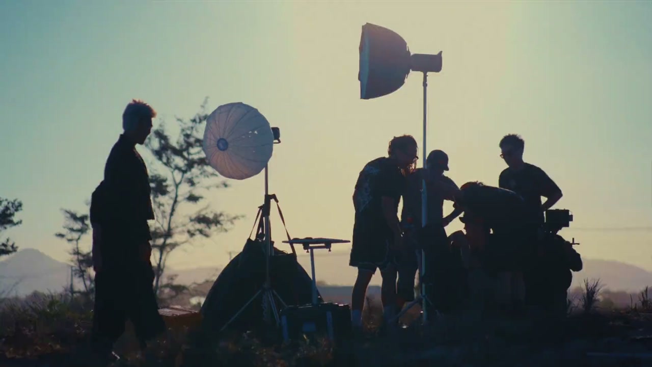Hoang Films crew and lighting rig silhouetted on location at golden hour