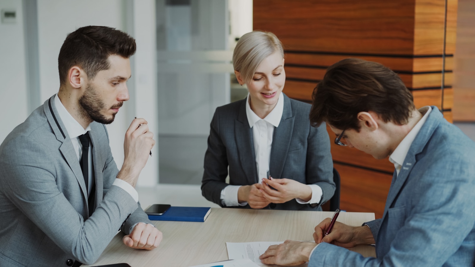 Business people reviewing and signing a contract at a table
