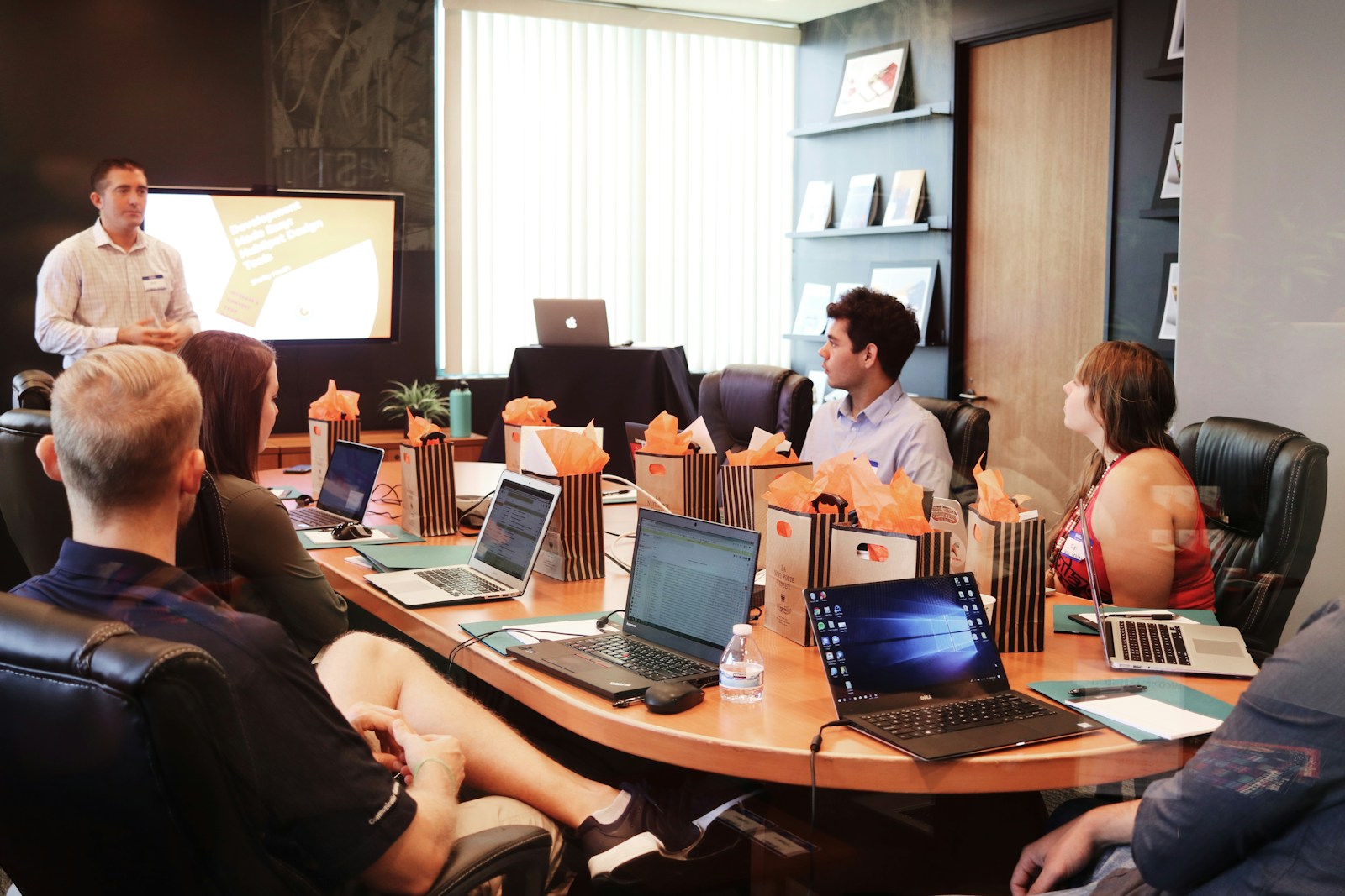 A presenter addressing a room of business people during a pitch meeting