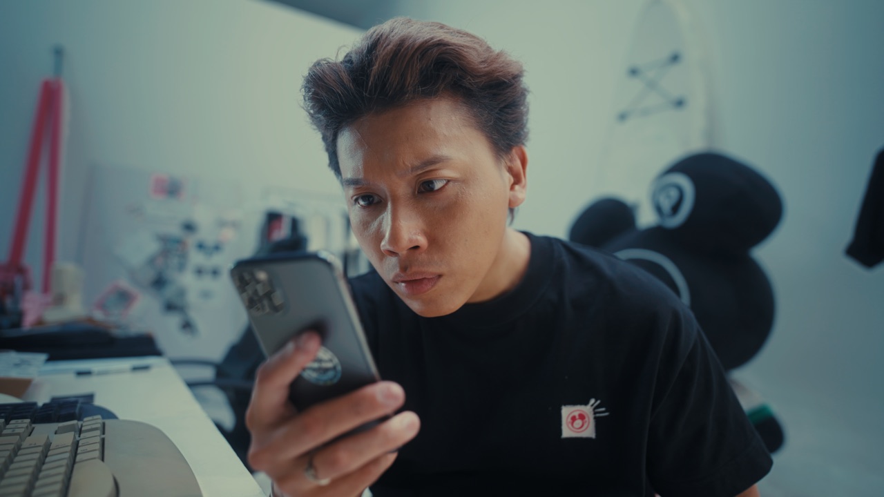 A still from a Vietnamese brand film produced by Hoang Films, a character reading a phone screen on set