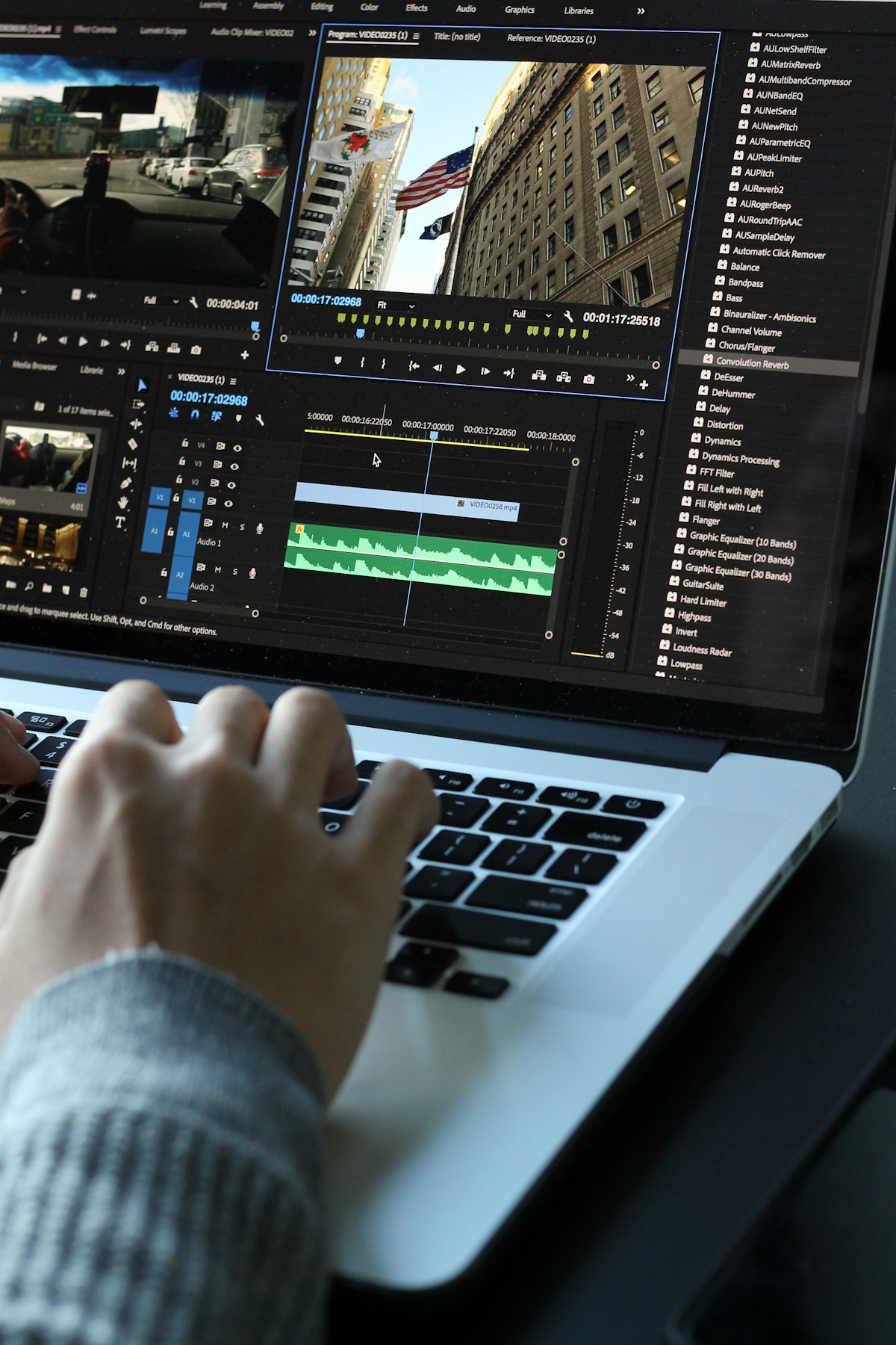 Person working on a laptop in a modern workspace, representing remote post-production workflow
